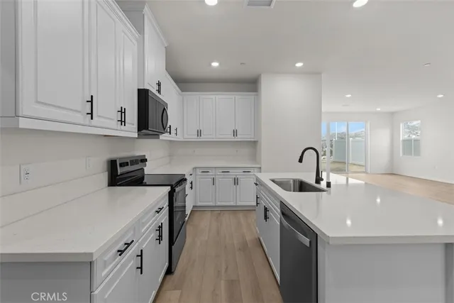 a kitchen with stainless steel appliances granite countertop a sink stove and cabinets