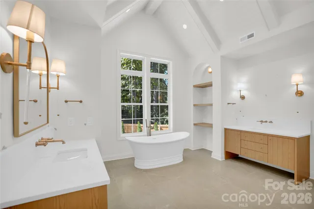 a bathroom with a double vanity sink a mirror and a bathtub