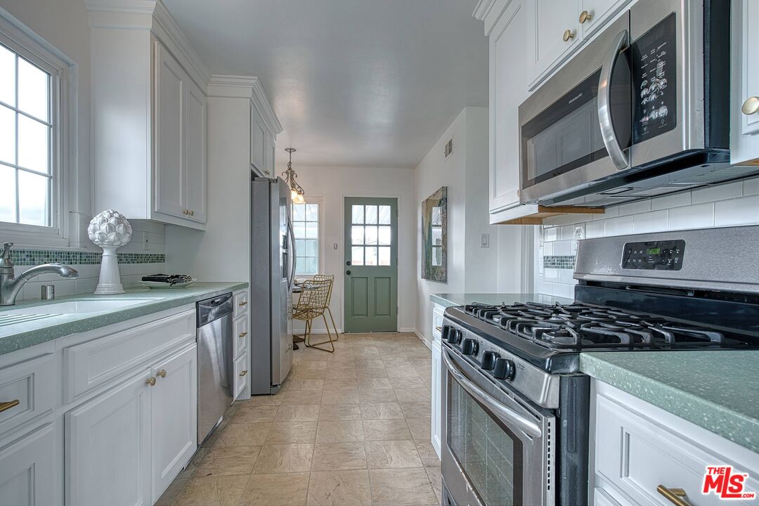 95 Kenneth Street Camarillo, CA 93010 - Photo 7 of 25 a kitchen with stainless steel appliances granite countertop a stove and a sink