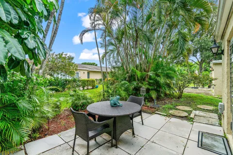 a backyard with table and chairs and potted plants