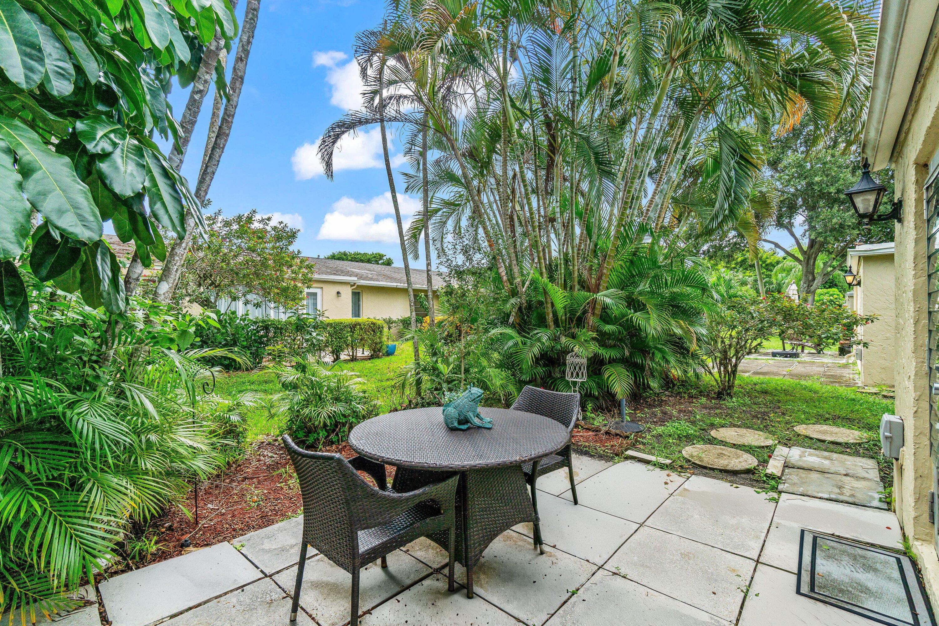13735 Flora Place, Unit B Delray Beach, FL 33484 - Photo 12 of 28 a backyard with table and chairs and potted plants