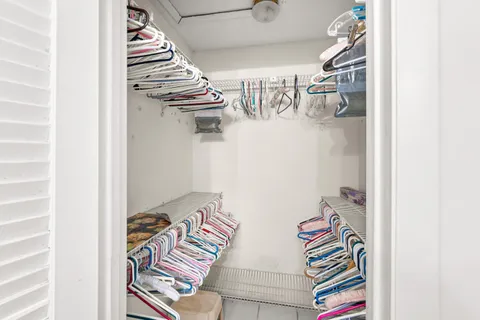 a view of walk in closet with clothes and shoes