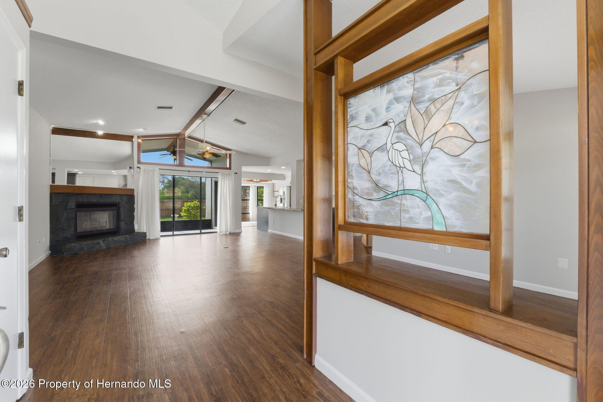 4966 Keysville Avenue Spring Hill, FL 34608 - Photo 5 of 50 a view of a hallway with wooden floor and a fireplace