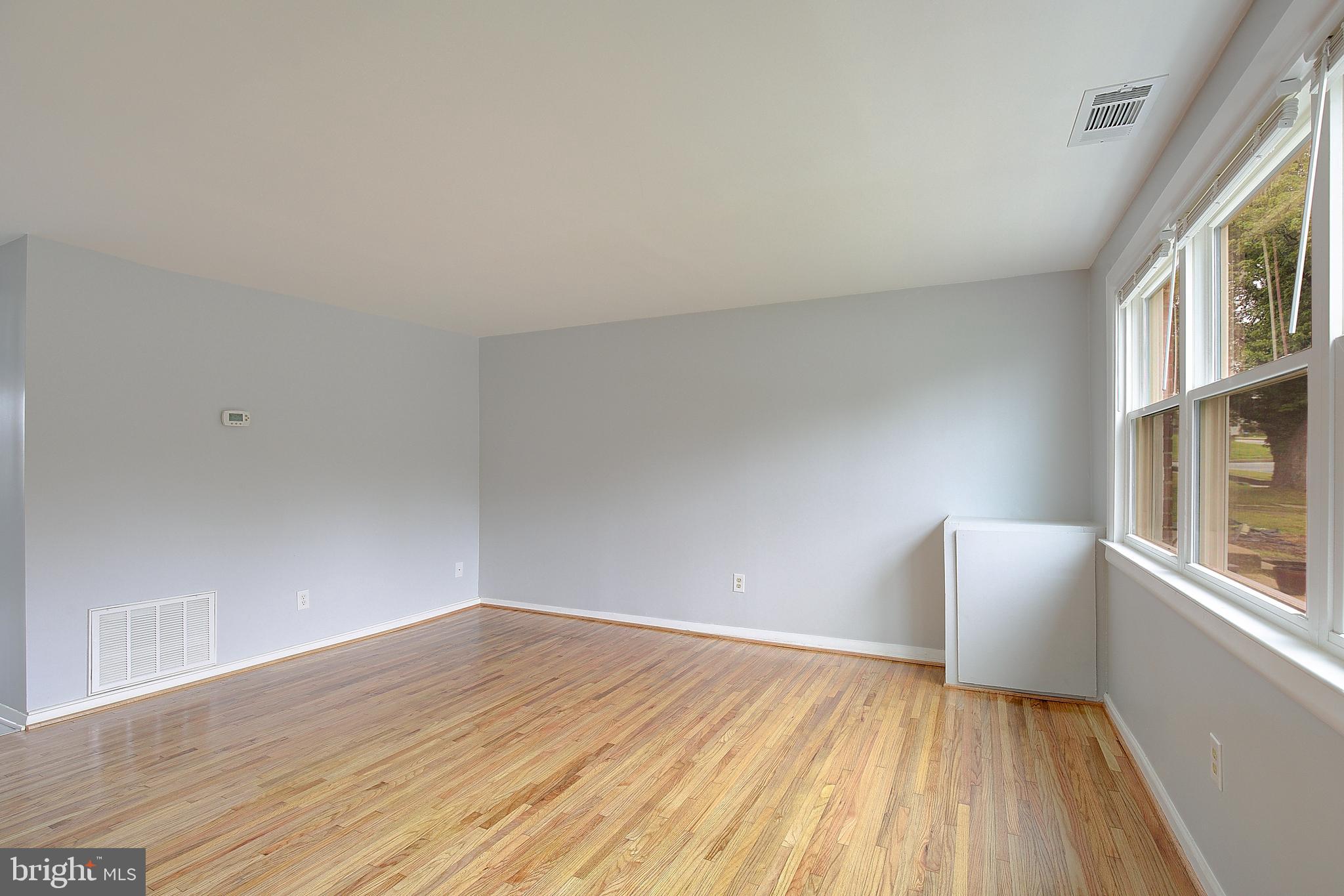 4330 Annapolis Road Baltimore, MD 21227 - Photo 4 of 34 a view of an empty room with wooden floor and a window