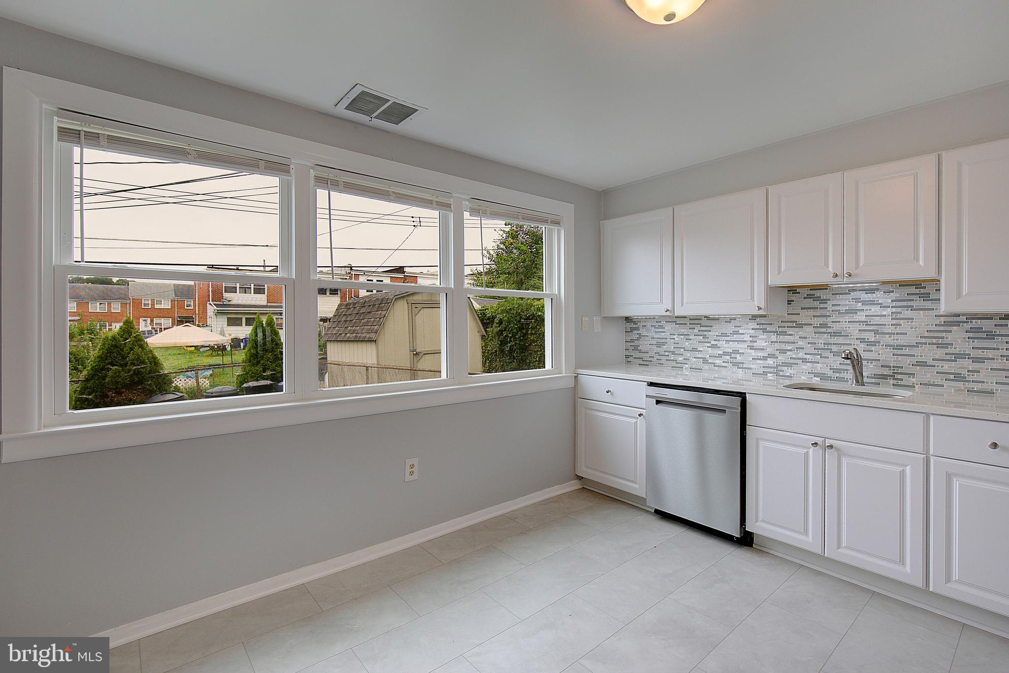 4330 Annapolis Road Baltimore, MD 21227 - Photo 10 of 34 a kitchen with granite countertop white cabinets and a large window
