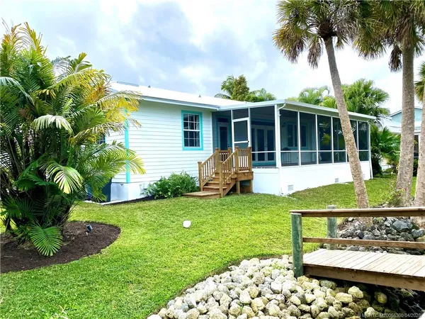 a view of a house with backyard sitting area and garden