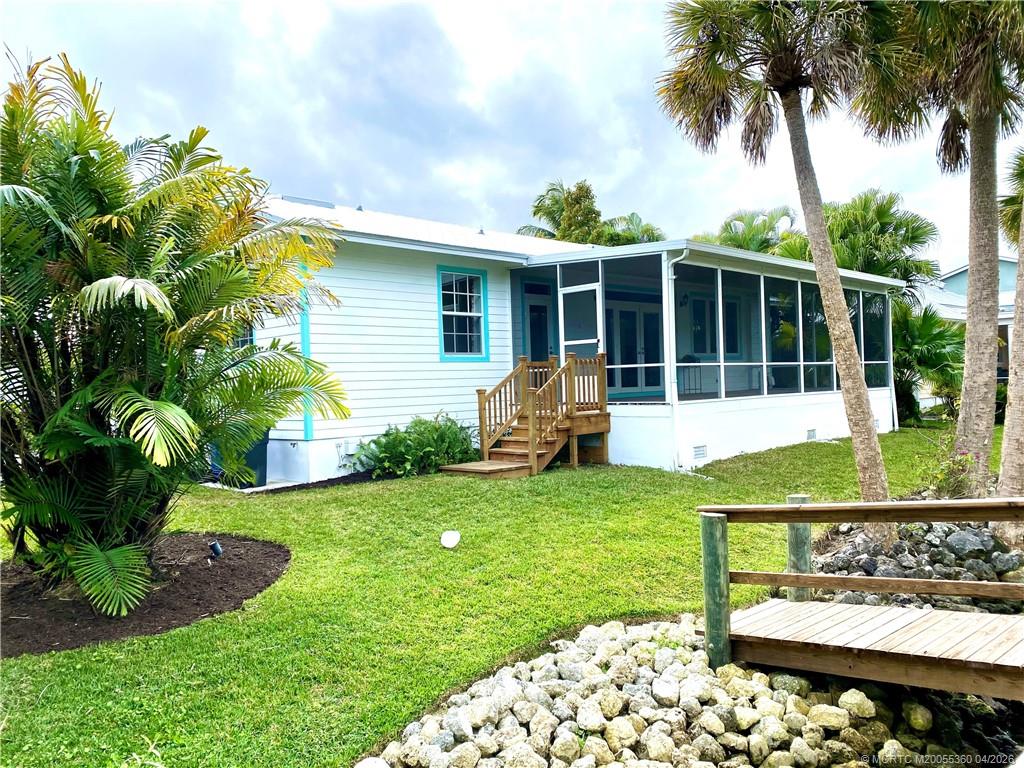625 Southwest Salerno Road Stuart, FL 34997 - Photo 13 of 21 a view of a house with backyard sitting area and garden