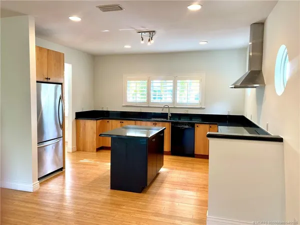 a kitchen with stainless steel appliances granite countertop a refrigerator a sink and a stove