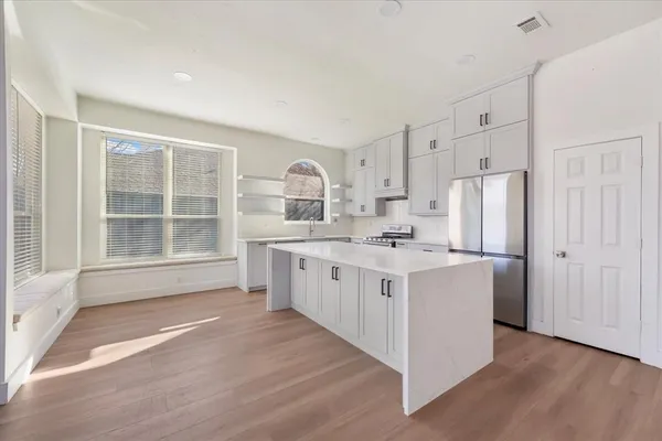a kitchen with white cabinets and white appliances