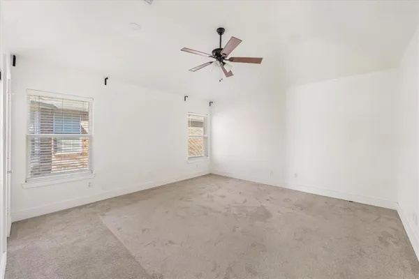 an empty room with closet and windows