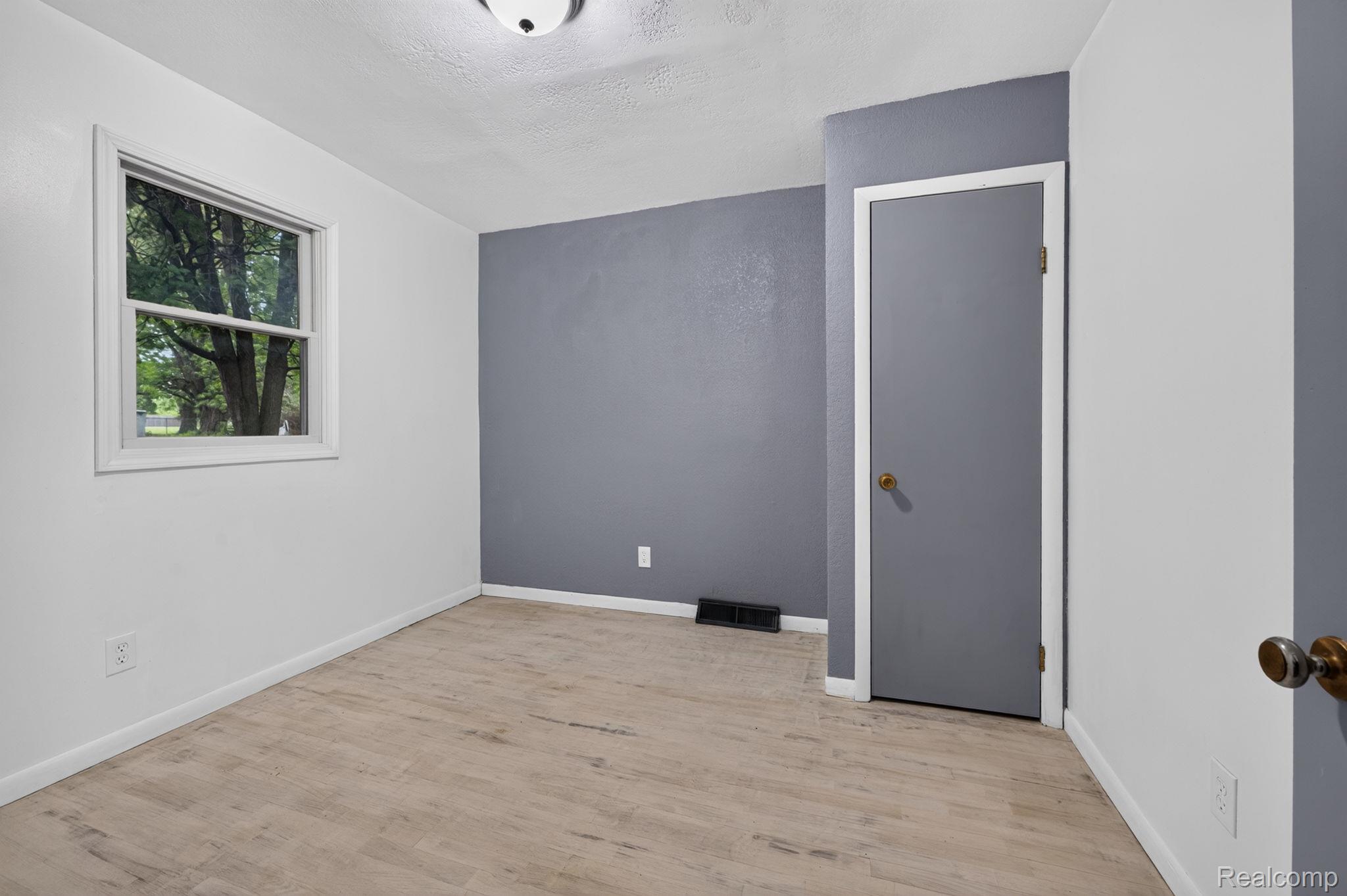 9288 Hilda Lane Flushing, MI 48433 - Photo 22 of 50 Room featuring wood-finish flooring, a neutral color palette, and a window with white trim