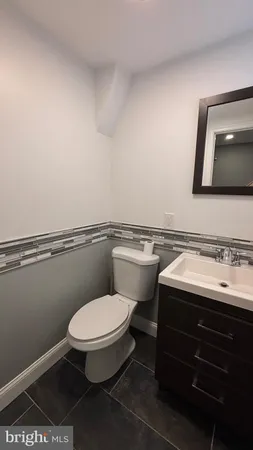 a bathroom with a toilet a sink and mirror