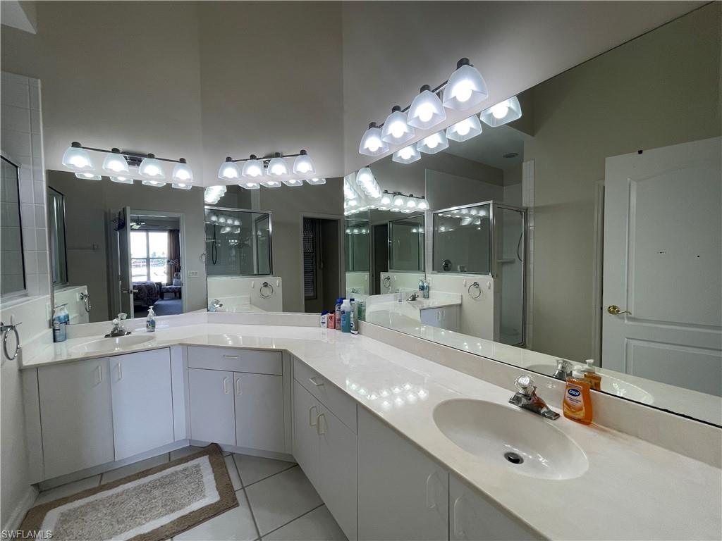 317 Sunrise Cay, Unit 204 Naples, FL 34114 - Photo 17 of 19 a bathroom with a sink vanity and a mirror