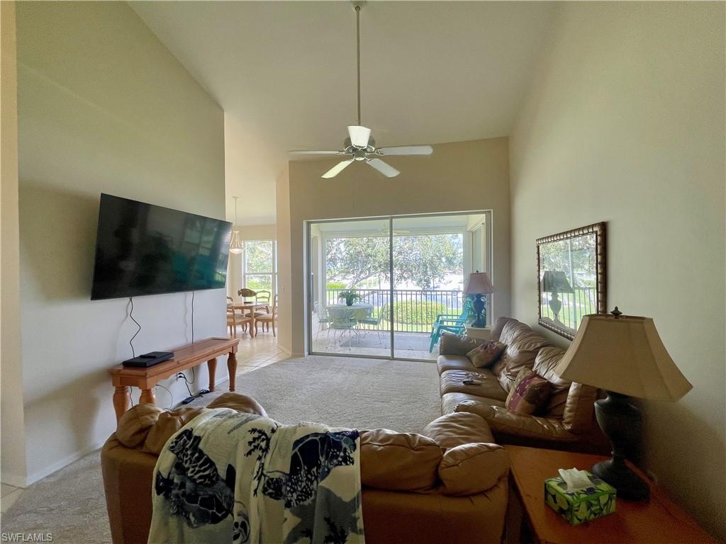 317 Sunrise Cay, Unit 204 Naples, FL 34114 - Photo 6 of 19 a living room with furniture a flat screen tv and a large window