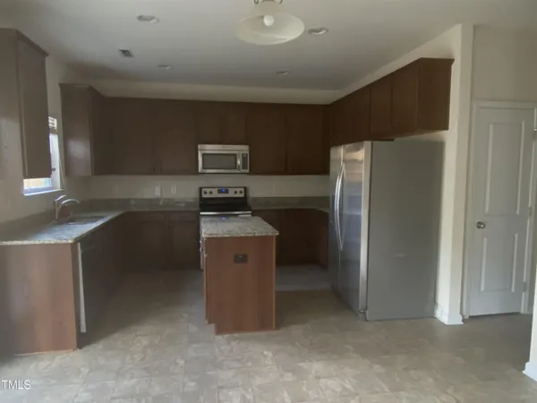 a kitchen with stainless steel appliances a refrigerator and a stove