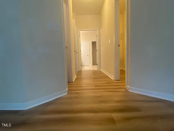 a view of a hallway with wooden floor