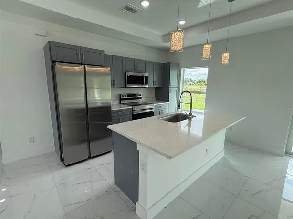 a kitchen with stainless steel appliances a refrigerator and a stove top oven