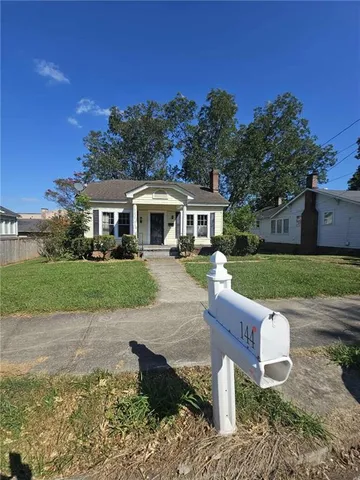 a front view of a house with a yard table and chairs