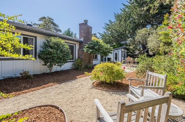 a balcony with table and chairs and potted plants