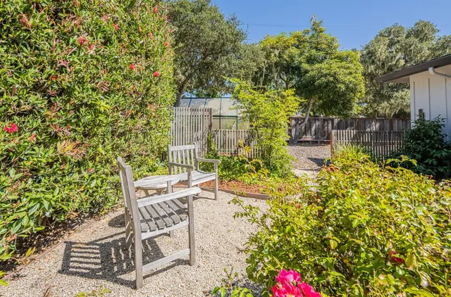 a view of a backyard with a barbeque and wooden fence