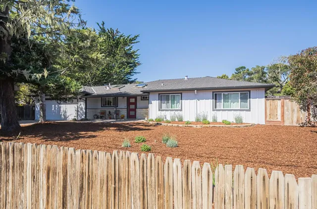a view of a house with a wooden fence