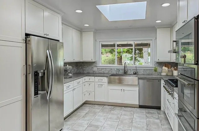 a kitchen with a refrigerator sink and cabinets