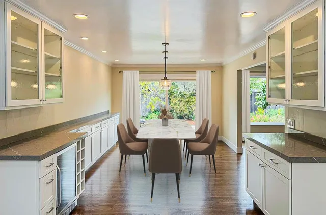 a kitchen with a table chairs and wooden floor