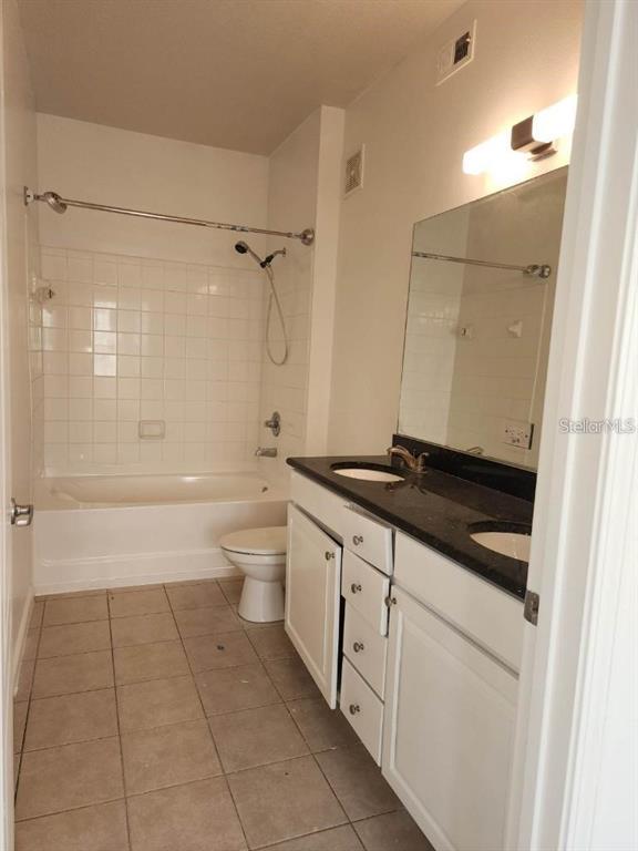 5255 Cane Island Loop, Unit 304 Kissimmee, FL 34746 - Photo 13 of 14 a bathroom with a granite countertop sink a toilet and shower