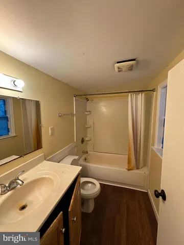 a bathroom with a granite countertop sink a toilet a mirror and shower