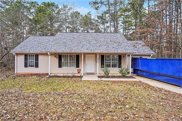 a front view of a house with a garden and yard