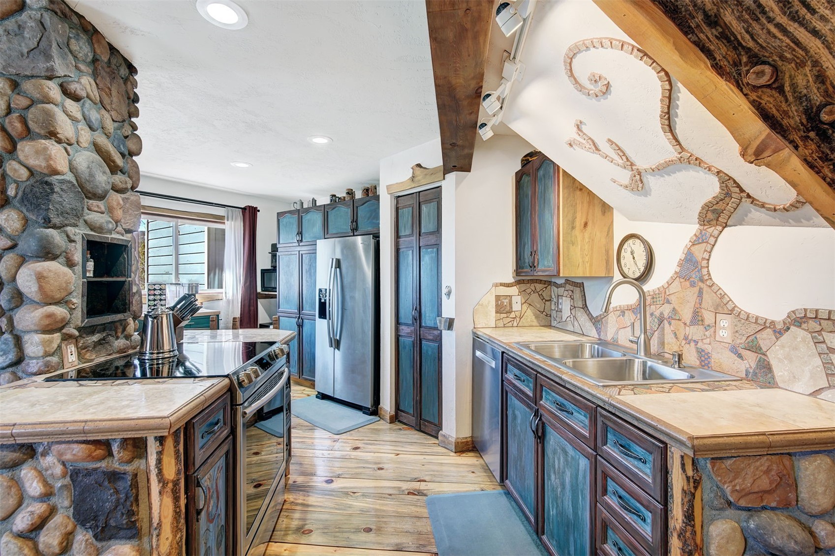 9460 Ryan Gulch Road, Unit 9460 Silverthorne, CO 80498 - Photo 4 of 39 a kitchen with stainless steel appliances granite countertop a sink a stove and a refrigerator