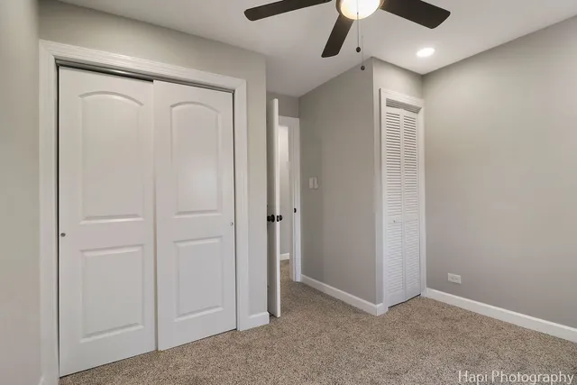 an empty room with closet and a ceiling fan