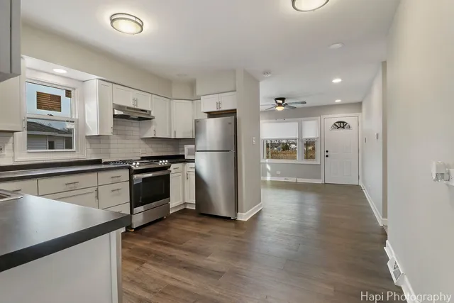 a kitchen with a refrigerator and a stove top oven