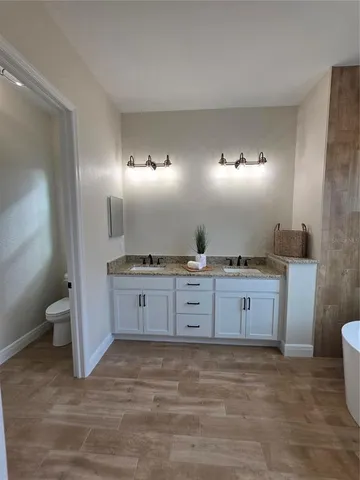 a large bathroom with a granite countertop sink and a mirror