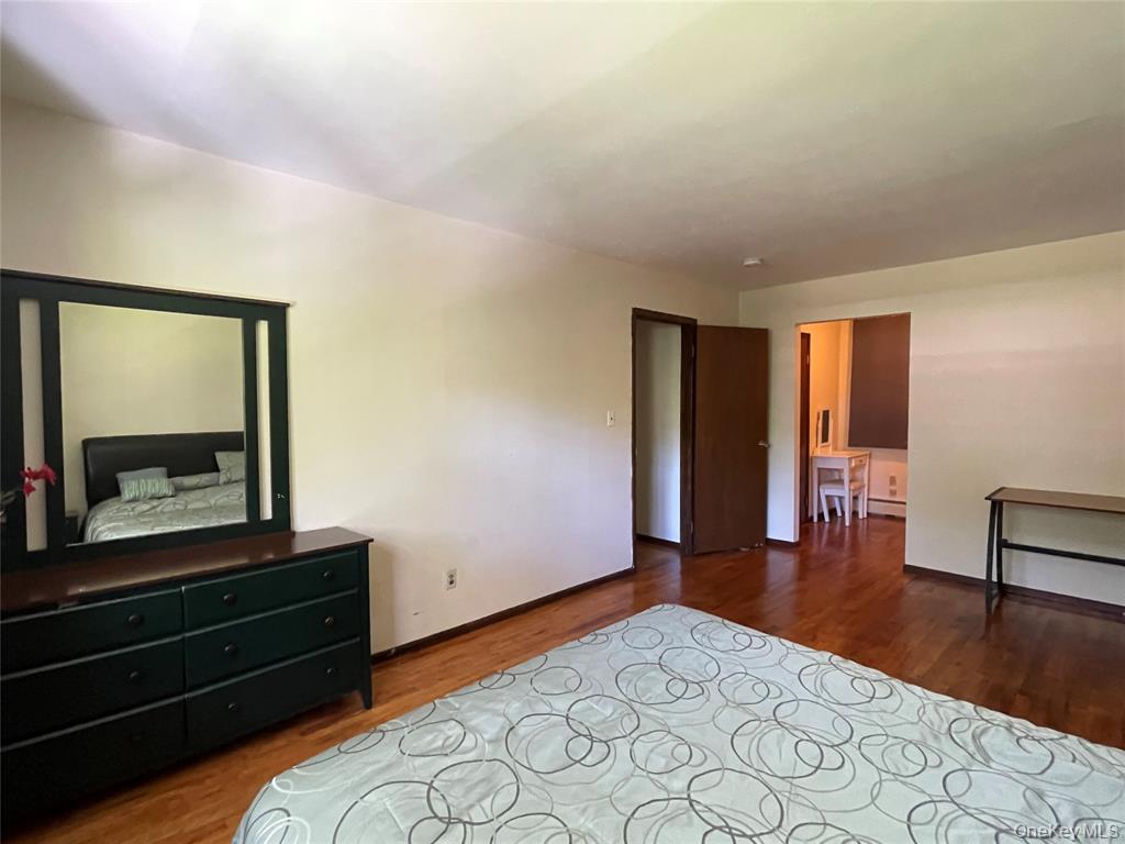 4 Cornwallis Road East Setauket, NY 11733 - Photo 12 of 16 a bedroom with a bed and a dresser with wooden floor