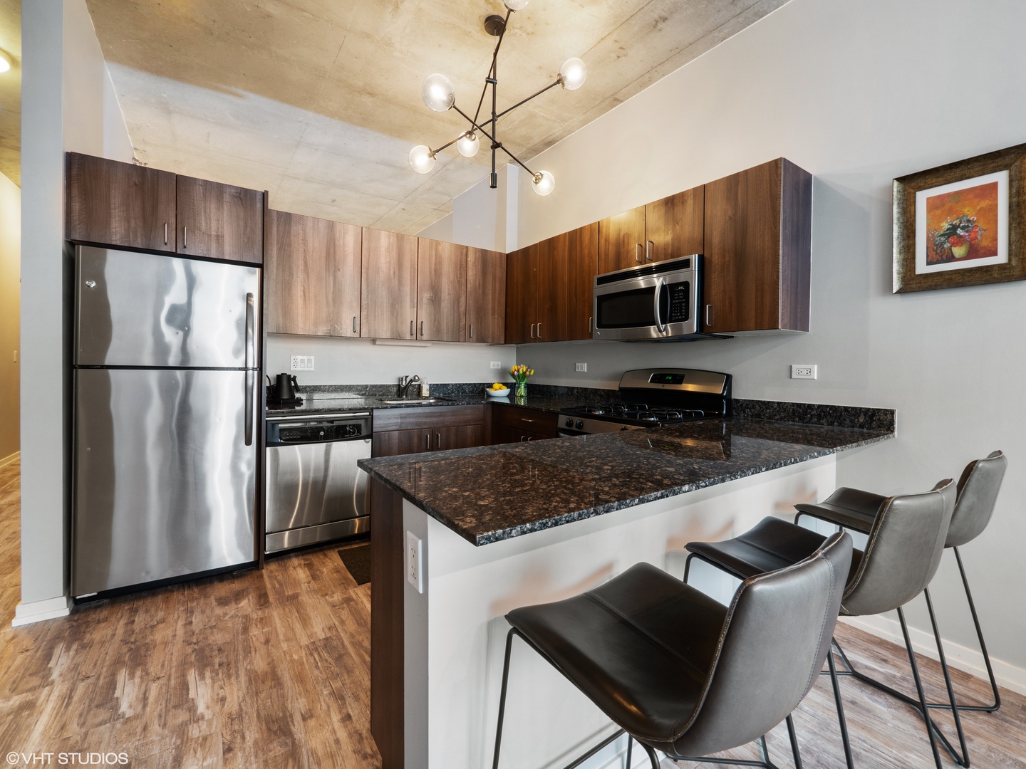 235 West Van Buren Street, Unit 2811 Chicago, IL 60607 - Photo 5 of 10 a kitchen with stainless steel appliances granite countertop a refrigerator a stove a sink dishwasher and a microwave oven with wooden floor