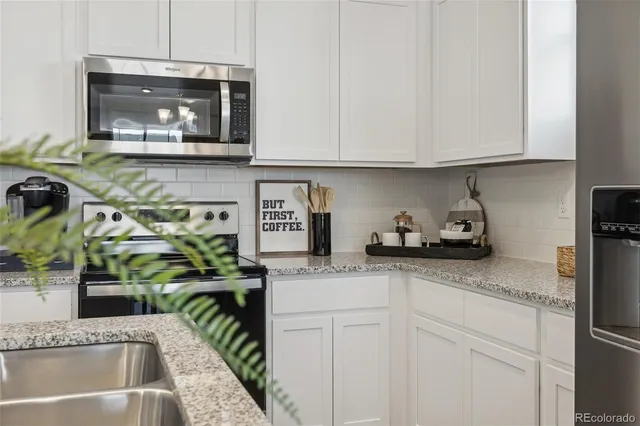 a kitchen with stainless steel appliances granite countertop a sink a stove and a microwave
