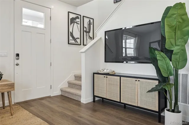 a view of a hallway with entryway and wooden floor