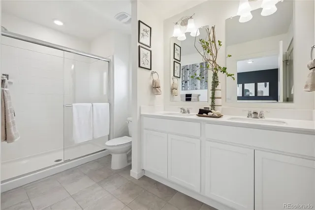 a bathroom with a double vanity sink mirror and toilet
