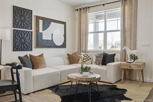 a living room with furniture a table and a potted plant