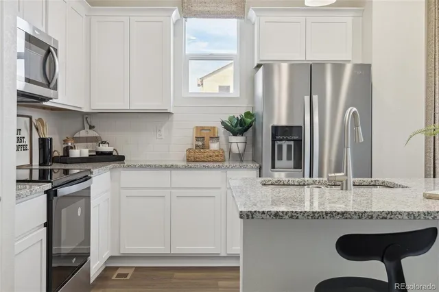 a kitchen with stainless steel appliances granite countertop a sink and cabinets