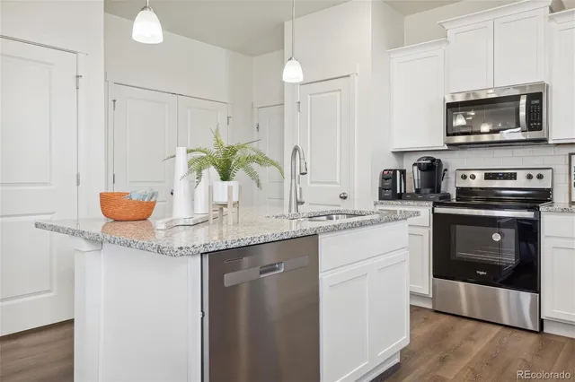 a kitchen with stainless steel appliances granite countertop a sink and a microwave