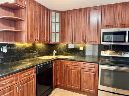 a kitchen with stainless steel appliances granite countertop a refrigerator and a stove