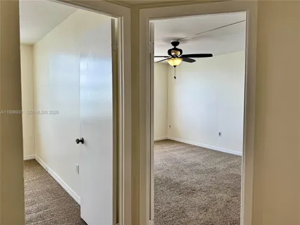 an empty room with closet and a chandelier fan