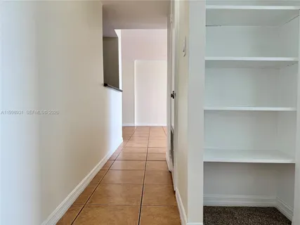 an empty room with closet and a hallway