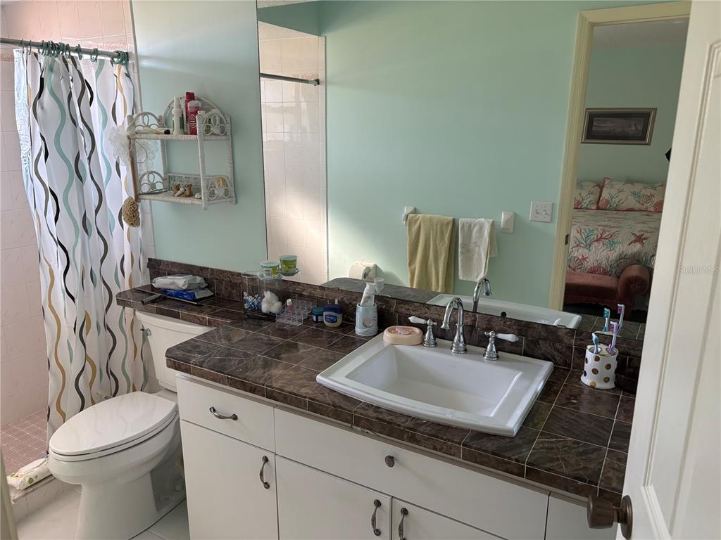 5338 Spanish Trail Holiday, FL 34690 - Photo 17 of 34 a bathroom with a granite countertop sink and a toilet