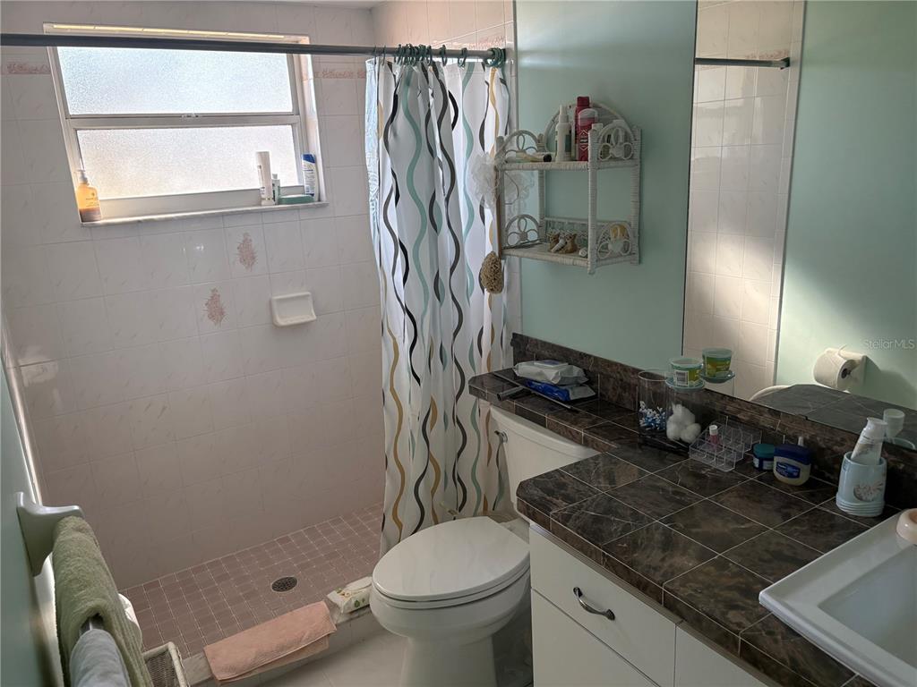 5338 Spanish Trail Holiday, FL 34690 - Photo 18 of 34 a bathroom with a granite countertop sink toilet and shower