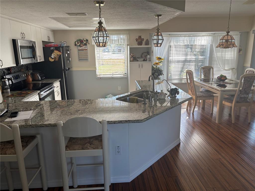 5338 Spanish Trail Holiday, FL 34690 - Photo 4 of 34 a kitchen island with granite countertop lots of counter top space and dining table