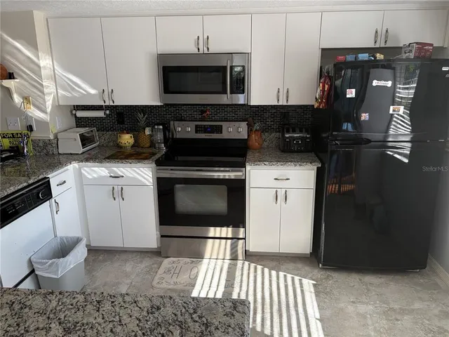 a kitchen with a stove and a white cabinets