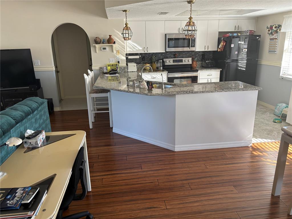 5338 Spanish Trail Holiday, FL 34690 - Photo 10 of 34 a kitchen with stainless steel appliances granite countertop a refrigerator a stove and a wooden floors